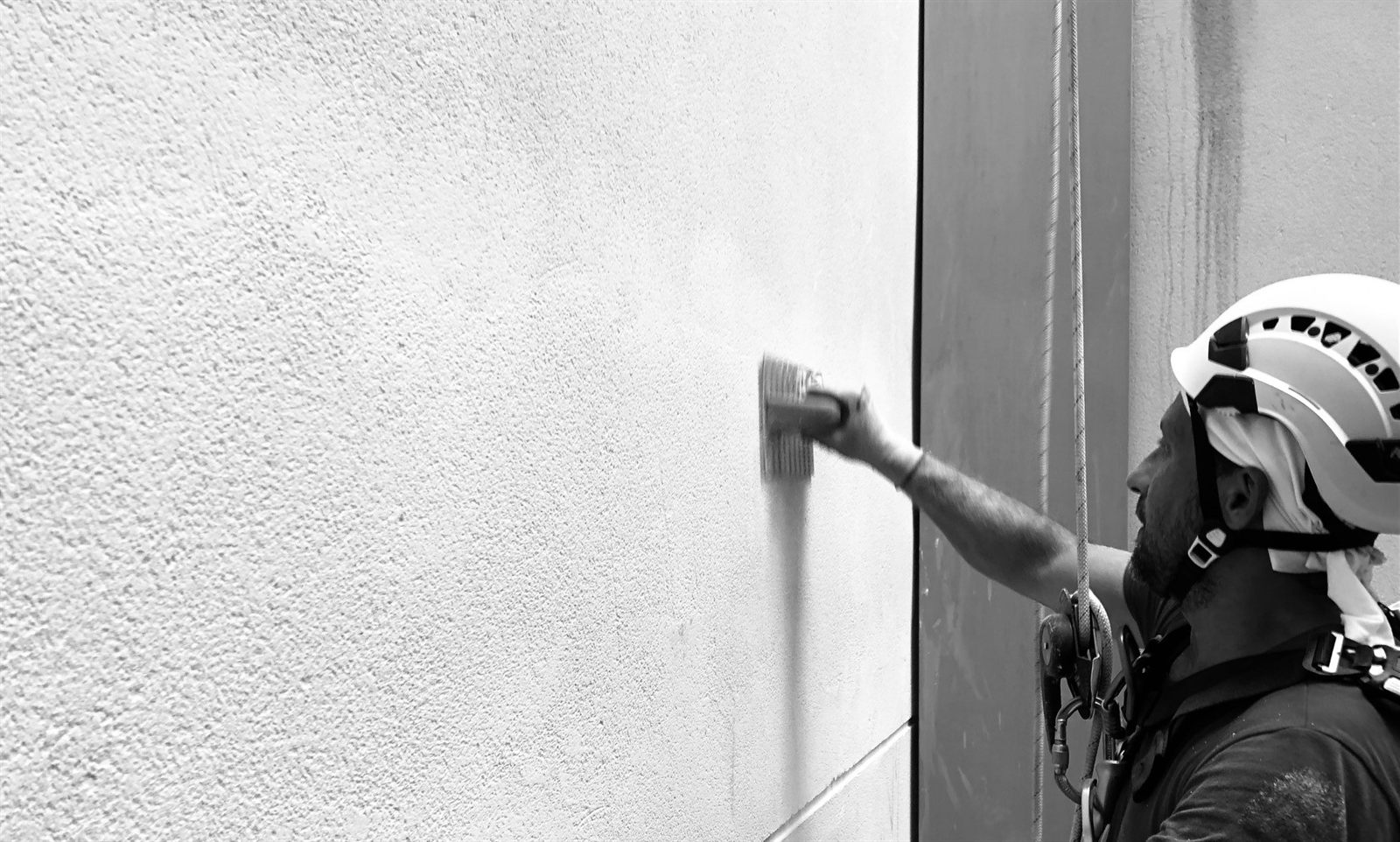 Pintura exterior de fachada en altura con acceso por cuerdas en Barcelona